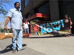 Chris Ramsaroop, left, and members from the Justice for Migrant Workers group are shown on Ouellette Avenue in downtown Windsor, Ont., on Sept. 6, 2016.