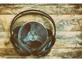 Music spool tapes and headphones on wooden table, retro style toned effect. Photo by Getty Images.