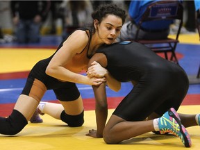 In this photo taken March 3, 2015,  Jade Dufour, left, of L'Essor takes on her opponent in the girls 51-kilogram division at the provincial high school wrestling championship in Windsor. Dufour captured a bronze medal in the 48-kg division at the world junior championships in France on Sept. 5, 2016.