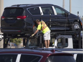 A worker loads a Chrysler Pacifica onto a transport truck at Windsor Assembly Plant, Friday, September 16, 2016.