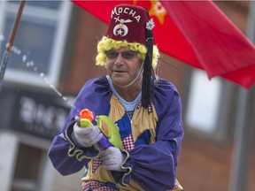 A member of the Sun Parlour Shrine Club entertains the crowd with a water gun as the Harrow Fair parade makes its way down King St., Saturday, August 3, 2016.  This is the 162nd Harrow Fair.