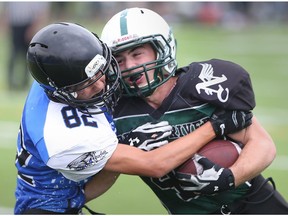 Liam O'Halloran, right, of the Belle River Nobles is tackled by Tecumseh Vista Academy's Jayson Demelo during WECSSAA senior boys football action in Tecumseh, Ontario on September 23, 2016.