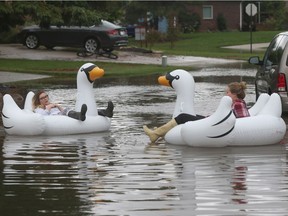 Tecumseh residents Erin Ballance and Keira Severs make the best of the flood while floating on Kimberly Drive on Thursday, Sept. 29, 2016.