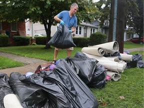 Joe Furlan throws flood-damaged items to the curb at his Lacasse Boulevard home in Tecumseh the day after record-setting rainfall hit the region.