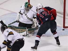 Windsor Spitfires Ben Johnson watches the puck bounce off the post behind the London Knights Jake Patterson at the WFCU Centre in Windsor on March 27, 2014.