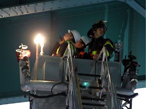 Inspectors from Transport Canada are joined by firefighters, city officials and engineers from the Ambassador Bridge as they inspect the underside of the 86-year-old bridge in Windsor on Thursday, Oct. 15, 2015.