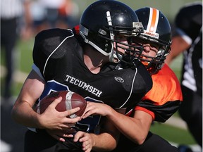 L'Essor's Dakoda Anger, right, tackles Tecumseh Vista's Zach Tasker in Tecumseh on Tuesday, September 20, 2016.