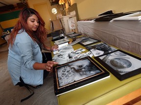 Yannin Ramirez prepares photos for an exhibit at the Windsor Youth Centre in Windsor on Thursday, September 22, 2016.