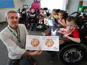 Jim Donohoo, a teacher at John McGivney Children's Centre is shown along with students on September 12, 2016. Tim Horton's is donating proceeds from the Smile Cookie campaign to the John McGivney Children's Centre.