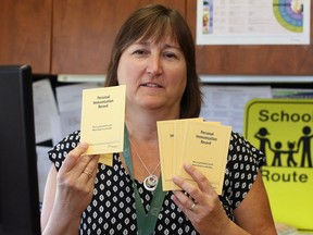 Judy Allen, manager of the Healthy Schools program at the Windsor-Essex County Health Unit, holds immunization cards on Friday, Sept. 2, 2016.