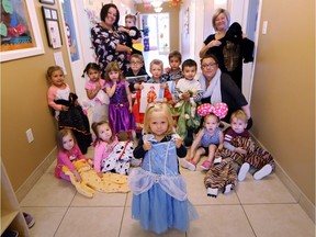 Two-year-old Carla Salatore, centre, along with students and staff from Kinder Academy, show off a selection of halloween costumes that will be donated to the Windsor-Essex Children's Aid Society.