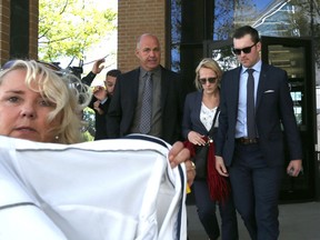 A woman holds a coat in the air in front of  DJ Cassady as he leaves the Superior Court of Justice accompanied by family and friends on September 27, 2016 in Windsor, Ontario. Cassady pleaded guilty to criminal negligence causing death.