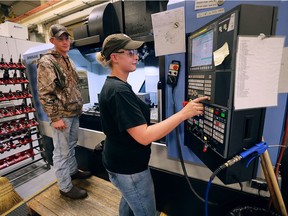 Gabe Levasseur, left, and Jaime Campbell, employees at A.V. Gauge & Fixture Inc. in Oldcastle, Ont., work on a CNC machine on Oct. 5, 2016.