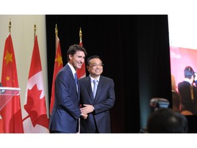 Canadian Prime Minister Justin Trudeau(L) and China Premier Li Keqiang embrace on September 23, 2016 at a conference of the Canada China Business Council in Montreal, Quebec.    /