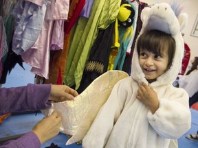 Camila Miele tries on a  pony costume during Costumes for Kids at the Sandwich Teen Action Group, Saturday, Oct. 24, 2015.