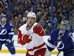 Justin Abdelkader (8) of the Detroit Red Wings and Ben Bishop (30) of the Tampa Bay Lightning look for a high puck during the third period of an NHL playoff game on April 15, 2016 in Tampa, Fla.