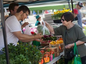 A transaction at the Bouchard Gardens table at the Downtown Windsor Farmers' Market in May 2015.