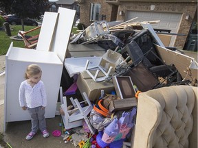 Zoey d'Entremont takes a look at her flood-damaged toys that are being thrown out after the basement flooded in her home on the 2900 block of McRobbie Crescent, Sunday, Oct. 2, 2016.