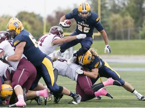 Windsor's Tarrence Crawford leaps over the McMaster defence for a touchdown during a game on Oct. 3, 2015.