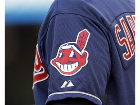 In this April 8, 2014 photo, the Cleveland Indians Chief Wahoo logo is shown on the uniform sleeve of third base coach Mike Sarbaugh during a baseball game against the San Diego Padres in Cleveland, Ohio. A Toronto court will hear arguments on an attempt to bar the Cleveland Indians from using their team name and logo in Ontario. The legal challenge by indigenous activist Douglas Cardinal comes on the same day that the baseball team takes on the Toronto Blue Jays in Game 3 of the American League Championship Series. THE CANADIAN PRESS/AP-Mark Duncan