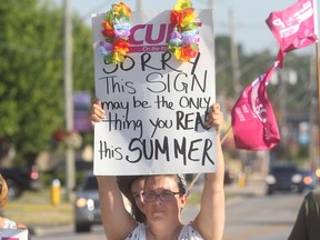 Striking CUPE library technician Michelle Griffiths pickets in front of the Tecumseh municipal building on Tuesday, July 12, 2016.