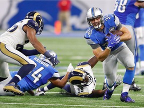 Zach Zenner (34) of the Detroit Lions runs for good yardage against Cory Littleton (58) of the Los Angeles Rams during second-half action at Ford Field on Oct. 16, 2016 in Detroit, Mich.