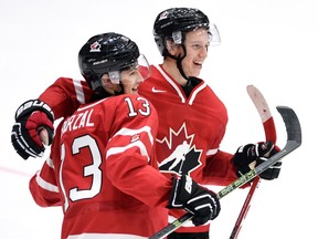 Canada's Mathew Barzal, left, and teammate Thomas Chabot celebrates their team's win over Switzerland in preliminary round hockey action at the IIHF World Junior Championship in Helsinki, Finland on Dec. 29, 2015.