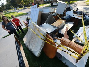 Julia Archer, 12, and her brother Joe Archer, 10, are shown next to a huge pile of flood damaged items at their Riverdale Ave. home in Windsor, ON. on Monday, October 3, 2016.