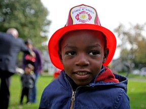 Mulenga Kanso, 3, dons a fire chief hat Tuesday during the kick off to Fire Prevention Week outside a Windsor-Essex Community Housing complex on Glengarry Avenue.