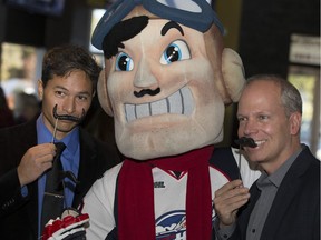 Bob Bellacicco, from left, from CTV News, Spitfires mascot Bomber, and Craig Pearson of the Windsor Star pose for a photo at the kick off for prostate cancer fundraising at John Max Sports and Wings on Lauzon Rd., Friday, Oct. 28, 2016.