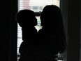 A sexual assault victim, holding her son as she looks out the window, finally tells her story Thursday after her abuser was sentenced to five and a half years in jail.  DAN JANISSE