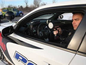 A Windsor police officer from the traffic unit uses a radar gun while looking for speeders along Division Road on Jan. 6, 2015, in Windsor.