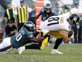 Pittsburgh Steelers' Jesse James, right, is dragged down by Philadelphia Eagles' Stephen Tulloch Sunday, Sept. 25, 2016, in Philadelphia.