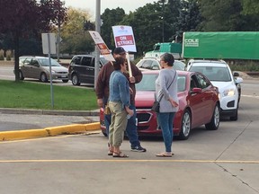Striking support staff workers delay cars from entering Assumption College in Windsor on Monday, Oct. 17, 2016.