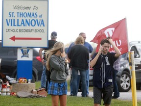 Striking support staff with the Windsor-Essex Catholic District School Board delayed cars from entering Villanova high school on Oct. 18, 2016 for several hours. A couple of students call for rides home after deciding to leave the school around noon.