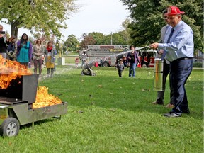 Ward 5 Coun. Ed Sleiman shows off his firefighting abilities Tuesday during a media conference to kick off Fire Prevention Week outside a Windsor-Essex Community Housing complex on Glengarry Avenue.