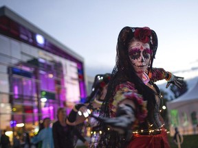 A woman dressed in a Day of the Dead costume dances with the Leadership Acadamy's Dance Fusion at the WAVES (Windsor's Artists, Visions, Energies & Sculptures) Festival outside the Windsor International Aquatic and Training Centre, Saturday, Oct. 1, 2016.