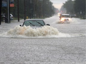 A car chugs through a flooded-out section of Lesperance Road near Riverside Drive on Sept. 29, 2016. Heavy rains caused major flooding in much of the area.