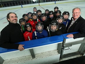 Chaderique Menard and Dr. Joe Casey (right) are photographed with one of the Windsor Wildcats hockey teams at Forest Glade Arena in Windsor on Thursday, October 13, 2016. The team is working with Dr. Casey and will be performing baseline tests for a concussion protocol.