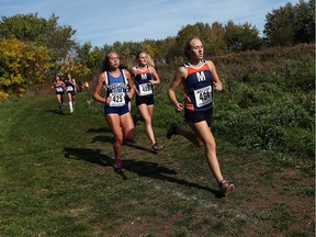 Maya Hannagan, right, leads Madison Burnham, left, and Chloe Walker in the early stages of their WECSSAA cross-country race at Malden Park in Windsor on Oct. 19, 2016.