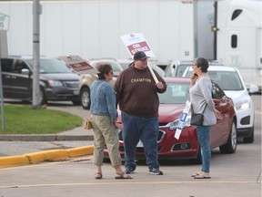 Striking support staff with the Windsor-Essex Catholic District School Board delay cars from entering Assumption College Catholic High School on Monday, Oct. 17, 2016.