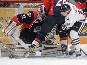 Windsor Spitfires goaltender Mario Culina keeps his eye on the puck as the Guelph Storm's Nic Sicoly reaches for it during action in Guelph Friday,  Oct. 7, 2016.