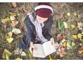 Reading a book outdoors. Autumn concept. Photo by Getty Images.