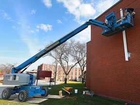 Scott Glasier, left, and Tony Vitarelli, members of the Bricklayers & Allied Craftworkers local 6 hang a cross at the Hotel-Dieu Grace Healthcare on Tuesday, November 15, 2016.