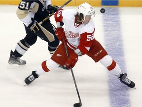 The puck flies past Detroit Red Wings' Tyler Bertuzzi  during an NHL preseason hockey game on Sept. 30, 2015, in Pittsburgh.