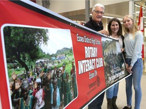 Students Olivia Sweet and Kaitlyn McCarthy, and retired teacher John Garingar display a banner for the Essex District High School Rotary Interact Club  in Essex.