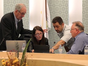 Ken Antaya, left, Robin Greenall, Nelson Santos and library board chair Richard Meloche converge during a five-minute recess to discuss if a motion could be heard from the gallery during Essex County Library board meeting on Oct. 26, 2016.