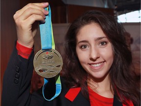St. Clair College student Meg Wilkinson holds the medals she designed for the 2016 FINA World Swimming Championships to be held in Windsor next week.