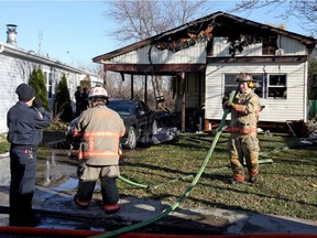 Firefighters clean up after spending more than six hours battling a house fire Tuesday in McGregor. The fire broke out around 5 a.m. Tuesday inside a mobile home at 23 Cedar Cresc. (TREVOR WILHELM/Windsor Star)