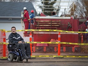 Donald Giesbrecht, 51, sits in his wheelchair outside his home on Robson Road in Leamington, while workers try to repair a gas leak on Nov. 24, 2016. Attempts to repair the leak have already taken more than a month.